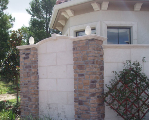 Stone columns with precast concrete post caps, wall caps, and keystone as well as stone veneer and foam brackets