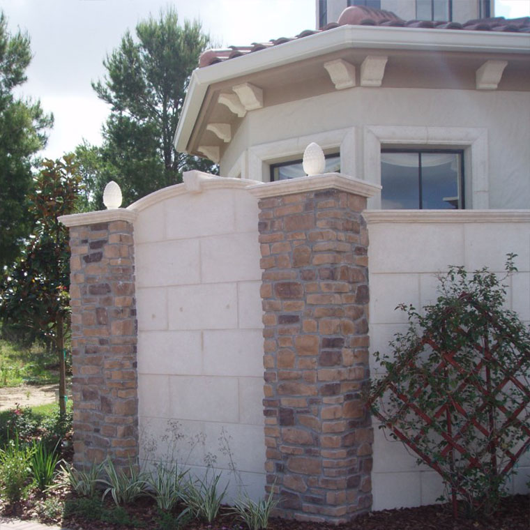 Stone columns with precast concrete post caps, wall caps, and keystone as well as stone veneer and foam brackets