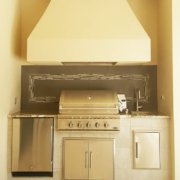 Stucco summer kitchen with custom tile backsplash